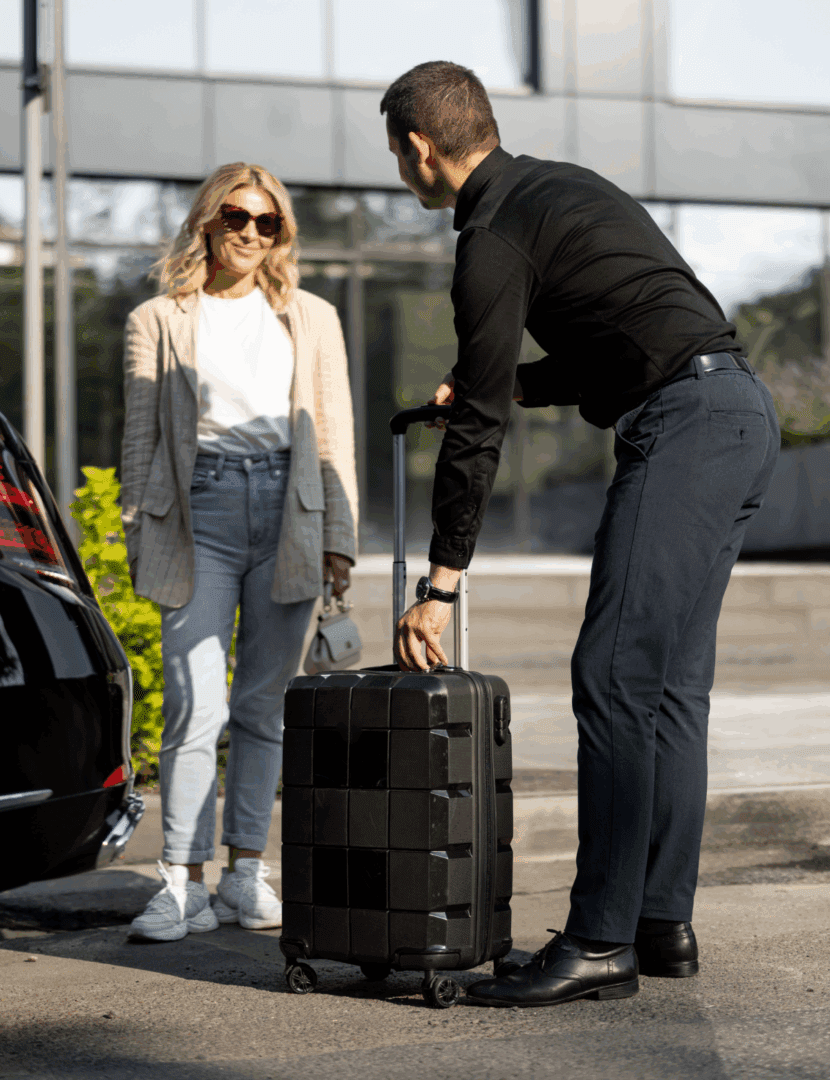 Man lifting suitcase for woman